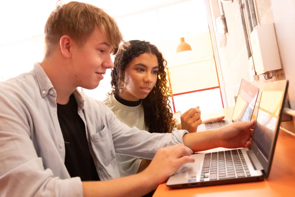 Performers College student duo using a laptop