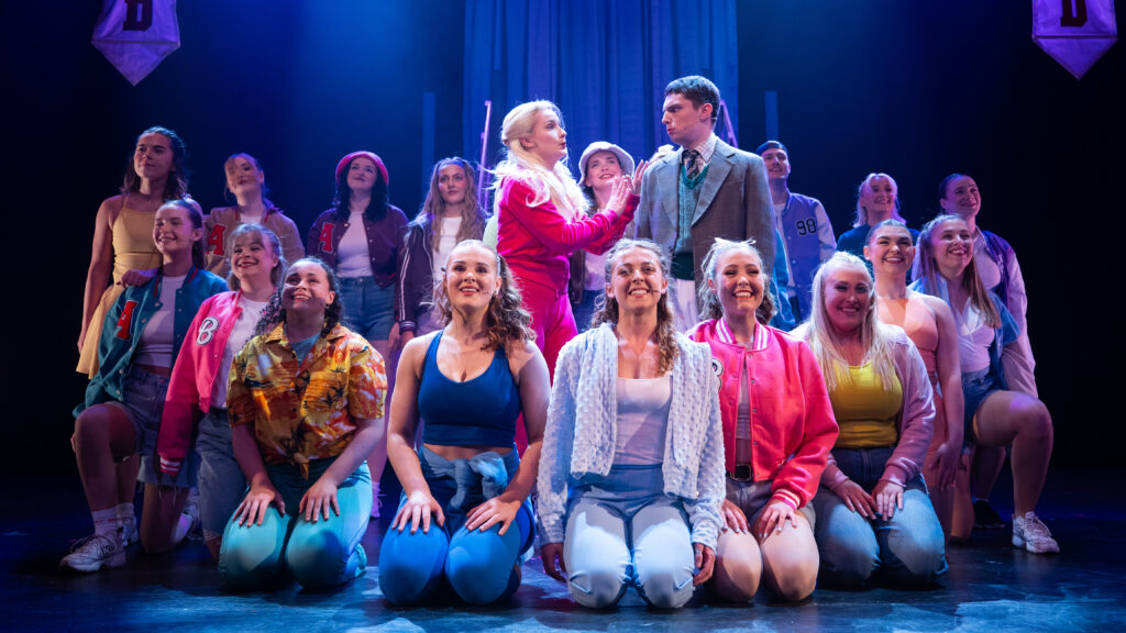 Legally blonde ensemble are assembled on stage